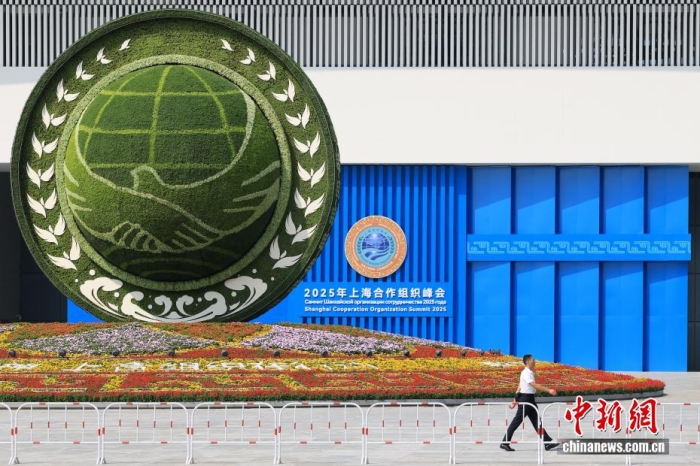 8月31日，天津，一名工作人員從2025年上海合作組織峰會(huì)主會(huì)場(chǎng)外的景觀花壇旁經(jīng)過。當(dāng)日，2025年上海合作組織峰會(huì)在天津舉行。<a target='_blank' href='/'><p  align=