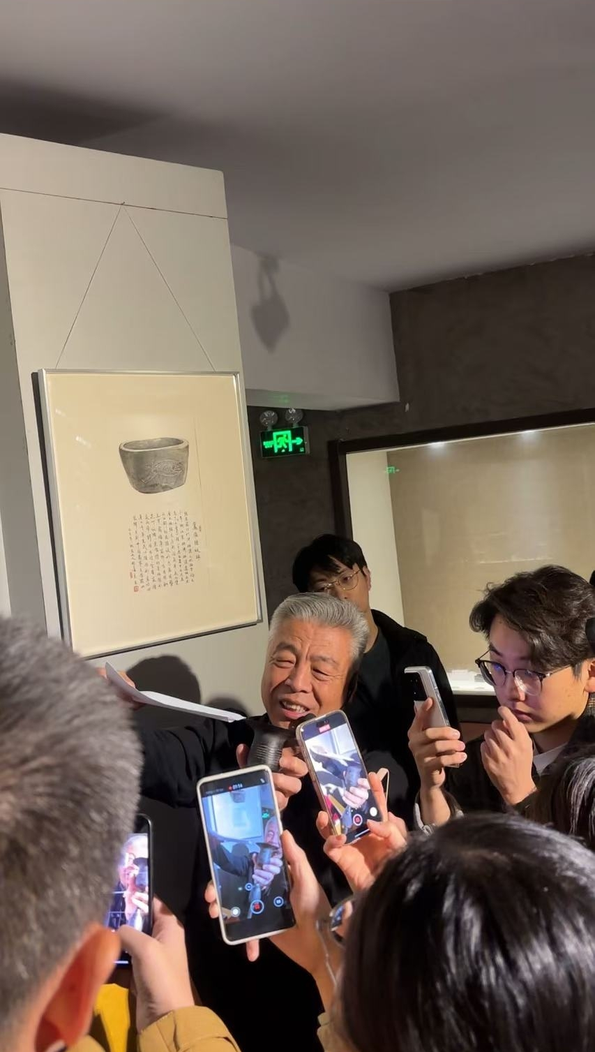 黑陶邢文化博物館館長邢葆東展示兩張相疊的A4紙，向記者解釋此為杯口的厚度。