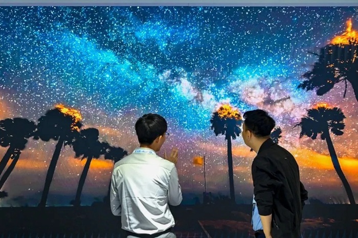 長春光博會(huì)希達(dá)電子展區(qū)，一位工作人員正在給一位觀眾講解。（長春新區(qū)供圖）
