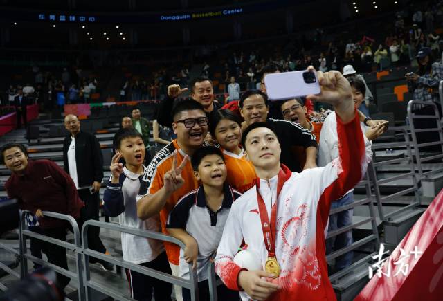 11月12日，十五運(yùn)會(huì)男籃成年組決賽，廣東隊(duì)獲得冠軍后，胡明軒與球迷們合影留念。張由瓊 攝