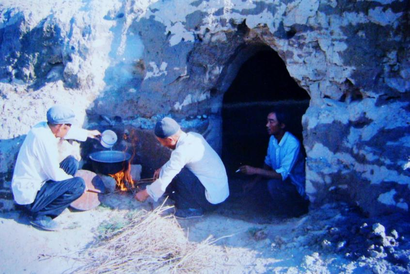 1983年，“六老漢”一代治沙人在“地窩子”生活做飯。新華社發(fā)（八步沙林場(chǎng)供圖）