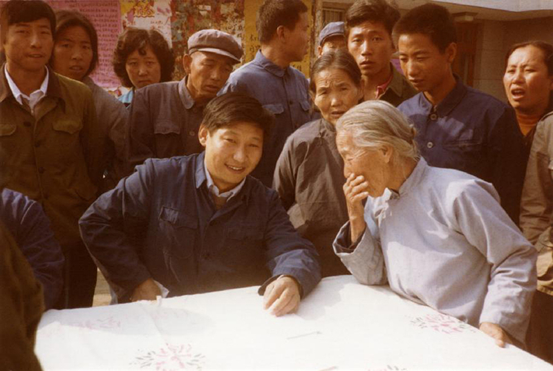 1983年，時(shí)任河北正定縣委書記的習(xí)近平（前排居中），臨時(shí)在大街上擺桌子聽取老百姓意見。