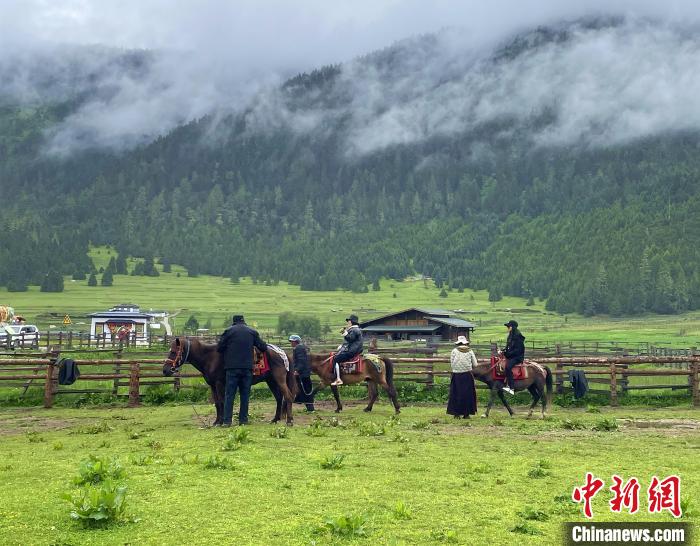 6月10日，游客在魯朗小鎮(zhèn)高山牧場景區(qū)體驗騎馬?！∪轿木?攝