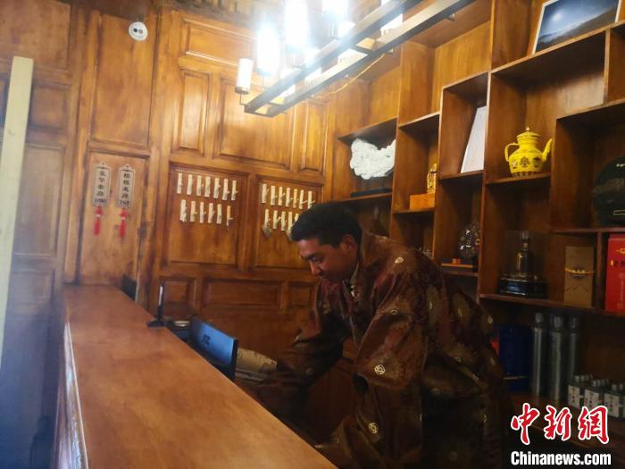 圖為桑杰才讓用電腦處理財(cái)務(wù)?！∈缝o靜 攝