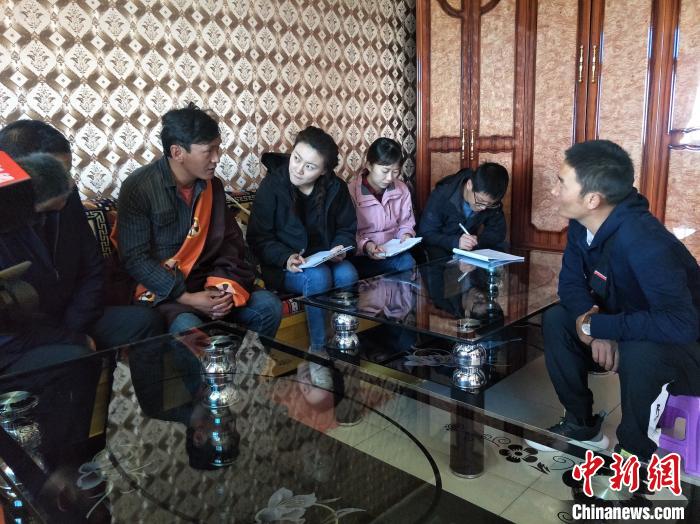 圖為調(diào)查組工作人員正在入戶調(diào)查?！∑钤鲚?攝