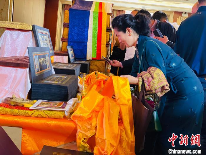 圖為現(xiàn)場(chǎng)藏族民眾向黃金書寫的大藏經(jīng)《甘珠爾》敬獻(xiàn)哈達(dá)?！O睿 攝