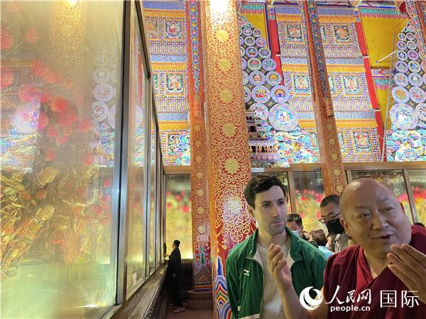 7月25日，省級非物質(zhì)文化遺產(chǎn)項目塔爾寺酥油花的代表性傳承人朋措堅參（右）在塔爾寺酥油花館講解酥油花的制作過程。人民網(wǎng) 謝瑩攝