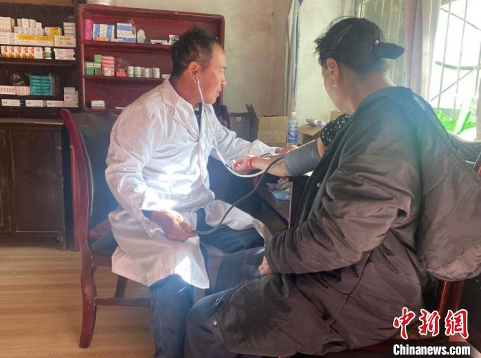 索木滾(左)為村民看病。　壤塘縣委宣傳部供圖