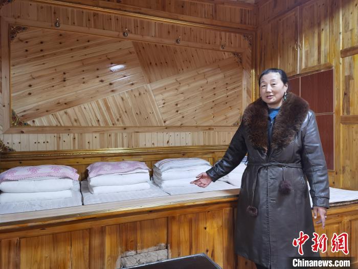 圖為德吉村村民鬧尖措介紹自家農(nóng)家樂?！∑钤鲚?攝
