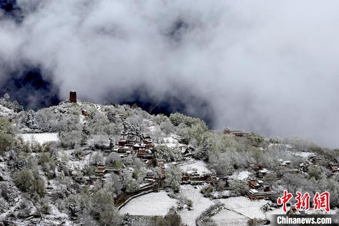 雪后的藏寨和碉樓構(gòu)成美麗的雪景?！〗党鯘衫?攝