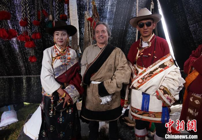圖為一名外籍?dāng)z影師(中)身穿藏服和藏族民眾合影留念?！●R銘言 攝