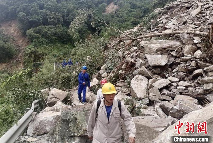電力搶險(xiǎn)人員徒步通過(guò)垮塌路段。　四川電力供圖