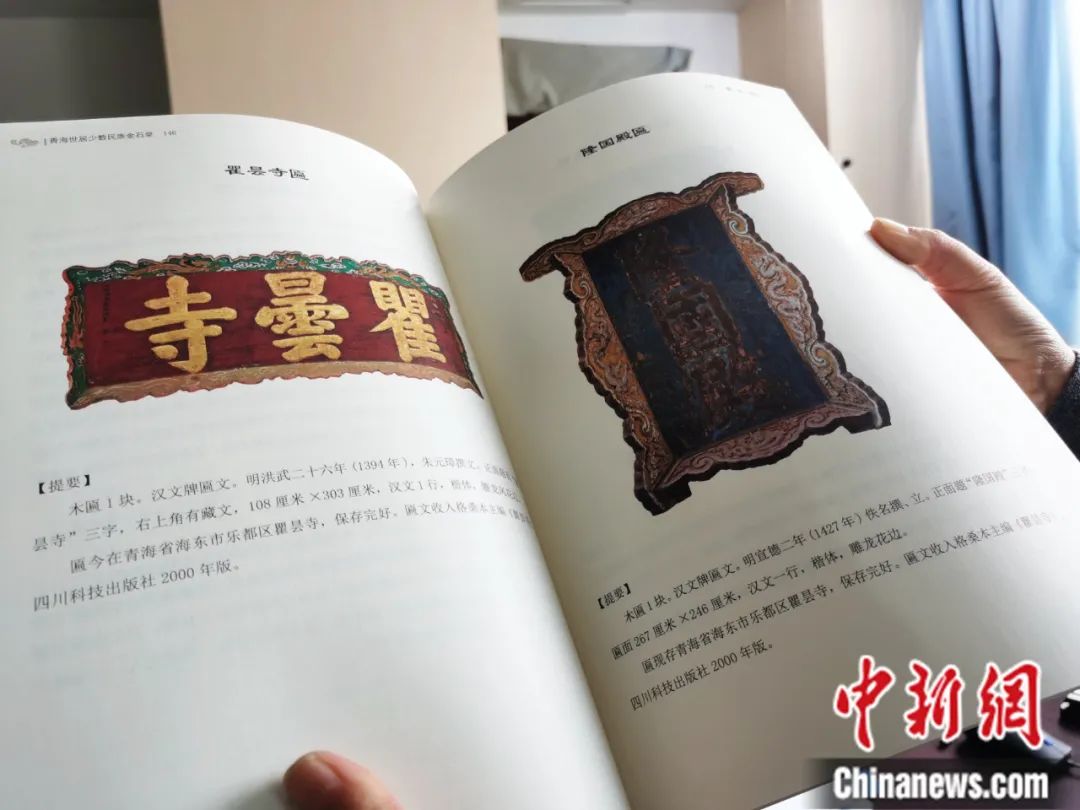 古籍保護(hù)人員展示介紹明代朱元璋撰寫(xiě)的青海瞿曇寺匾(左)的出版書(shū)籍。張?zhí)砀?攝
