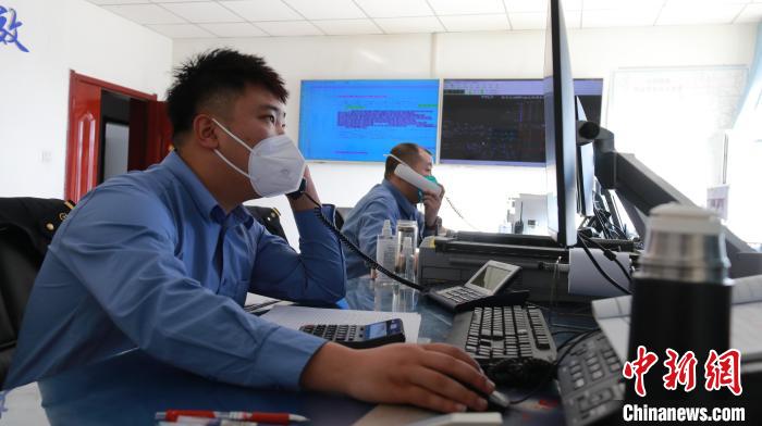 圖為貨運調(diào)度人員與外勤工作人員聯(lián)系掌握車輛裝載情況?！±钌?攝