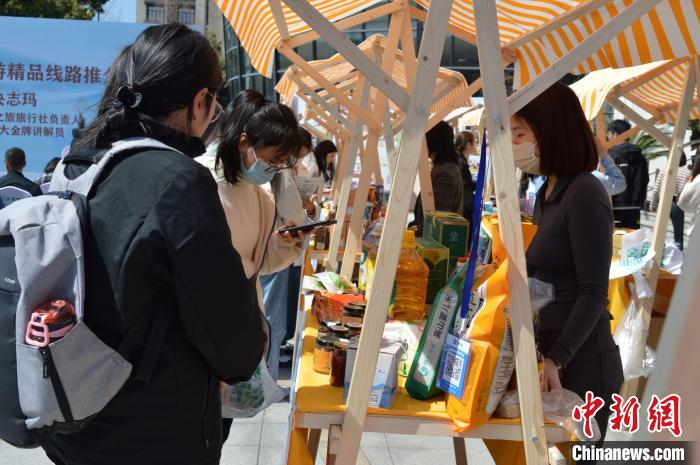 活動現(xiàn)場高校師生選購理塘農特產品?！≈炝杞?攝