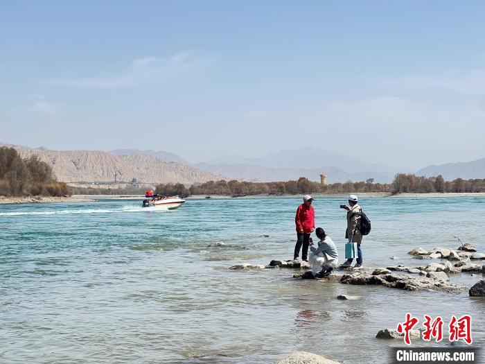 圖為游客在黃河岸畔游玩，并與黃河合影留念?！∑钤鲚?攝