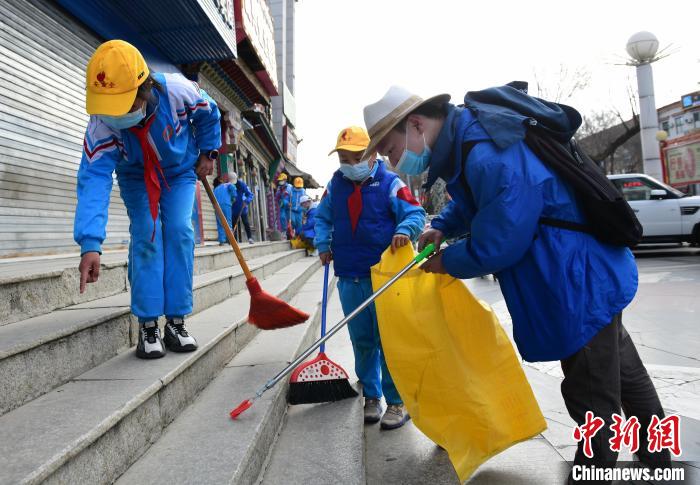 圖為拉薩市小學(xué)生打掃街道?！∝暩聛硭?攝