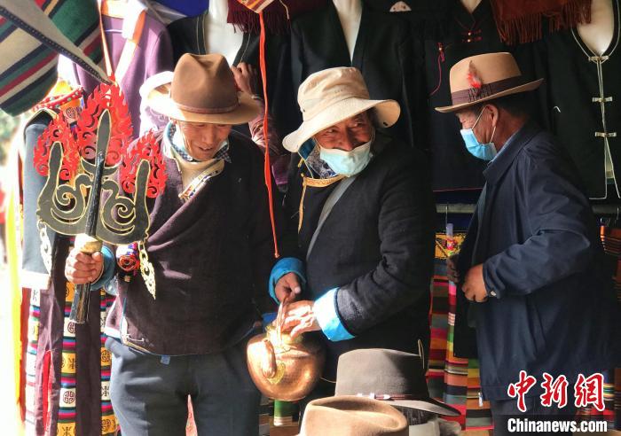 圖為三位藏族老人在集市上聊天交談?！∪轿木?攝