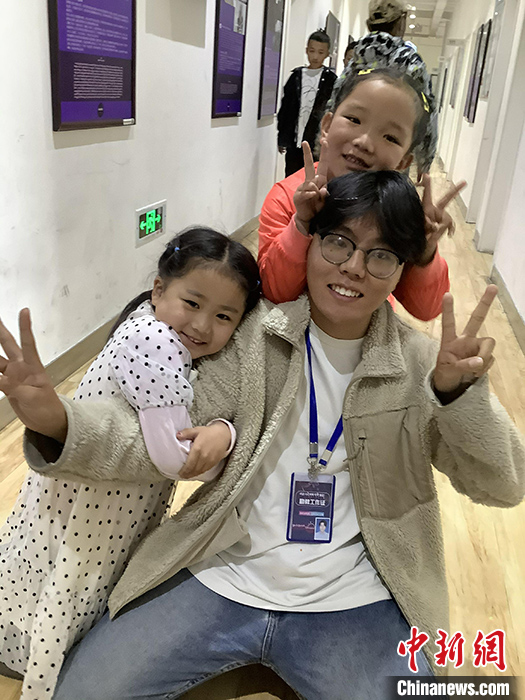 “Z世代”旦真旺加認為，拉薩是一座開放與包容的城市，記憶中的拉薩是彩色的。2021年，旦真旺加從浙江大學(xué)漢語言文學(xué)專業(yè)畢業(yè)后，他選擇回到拉薩，成為一名漢語文實習(xí)助教。圖為8月4日，旦真旺加在課間陪學(xué)生玩耍。 <a target='_blank' ><p  align=