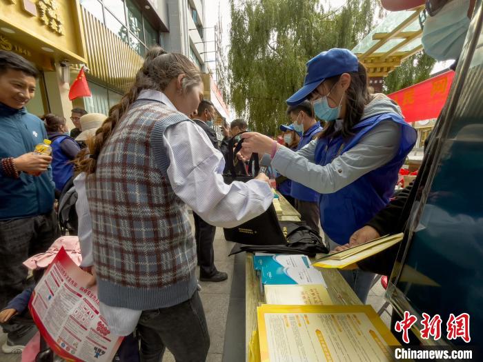 圖為志愿者為市民發(fā)放網(wǎng)絡(luò)安全宣傳手冊?！≈x牧 攝