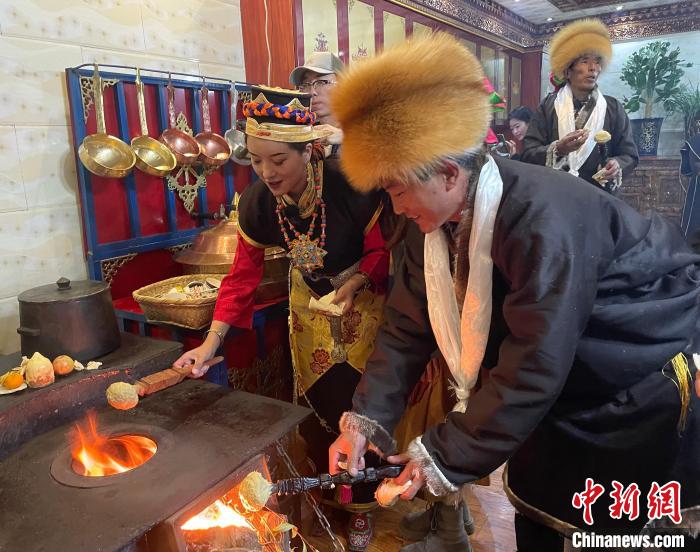 圖為人們?cè)诨鹕峡竟?jié)日美食“結(jié)達(dá)”?！∪轿木?攝