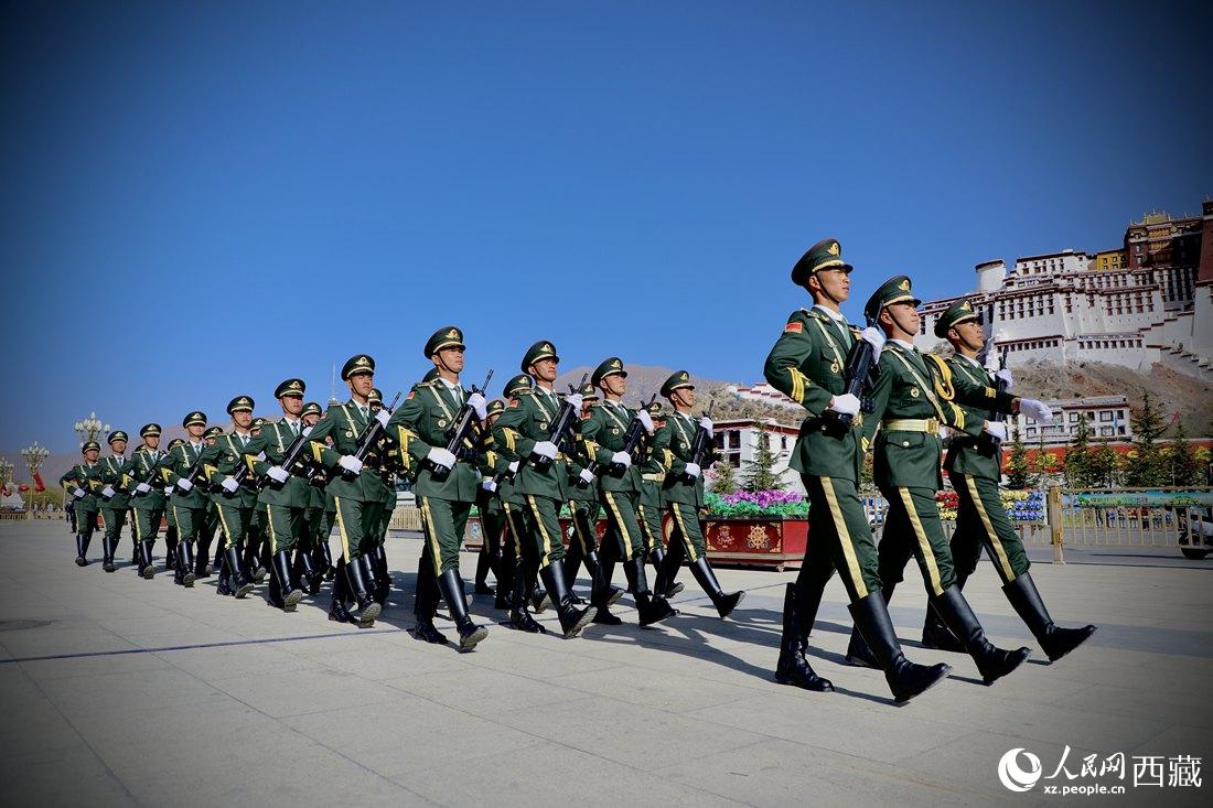 國旗護衛(wèi)隊隊員緊握鋼槍，踏著威武雄壯的步伐，走向國旗臺。人民網(wǎng) 次仁羅布攝