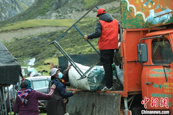 圖為工作人員幫助牧民們卸家具?！÷蹇?攝