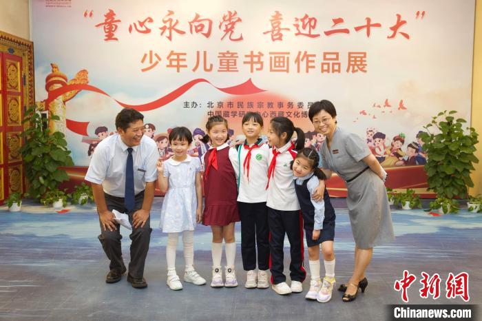 圖為與會(huì)嘉賓與入選畫作的“小作者”們在展覽上合影?！≈袊貙W(xué)研究中心供圖