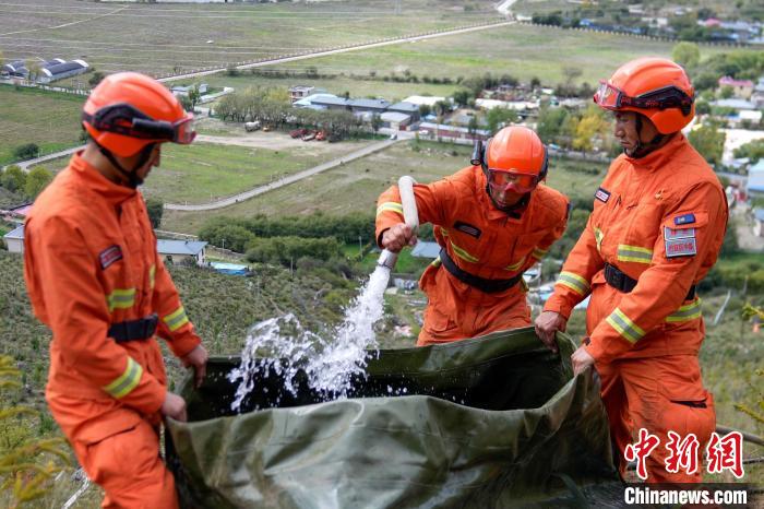 技能大練兵過(guò)程中，消防員在陡坡上向蓄水池注水?！±顕?guó)燾 攝