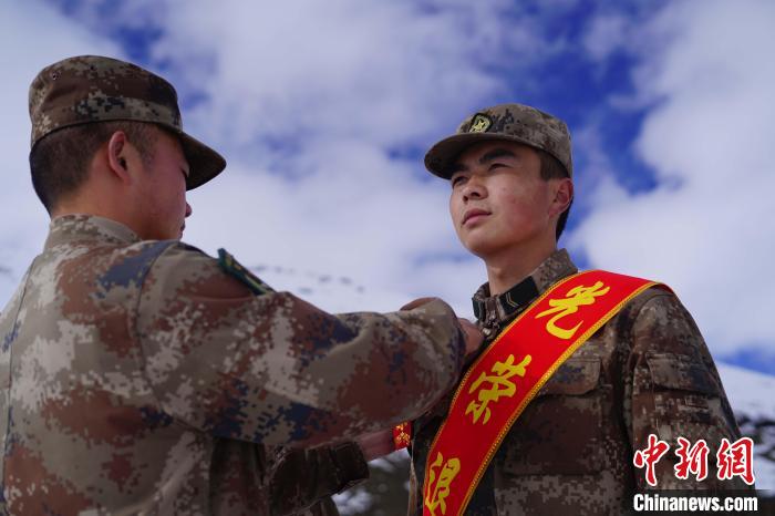 排長(zhǎng)王朝偉(圖左)給退伍老兵佩戴大紅花?！∥鞑厣侥宪姺謪^(qū)某團(tuán)供圖