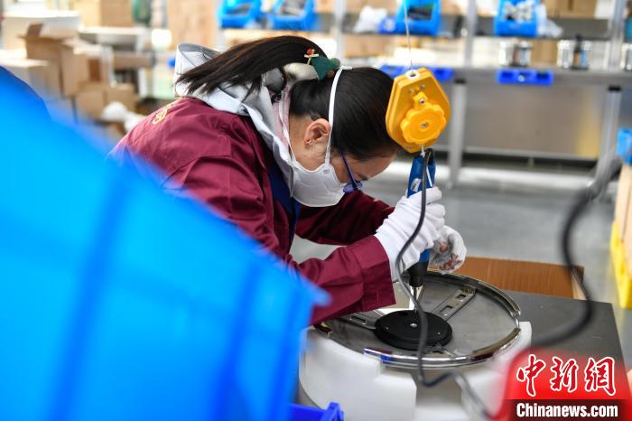 圖為工人正在組裝炊具。　貢嘎來松 攝