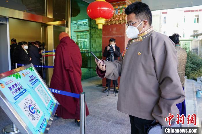 圖為政協(xié)委員掃場所碼進(jìn)入會(huì)場?！〗w波 攝