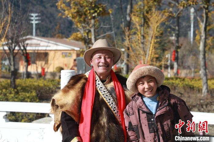 圖為林芝市巴宜區(qū)布久鄉(xiāng)仲果村村民桑杰與孫子一起參加藏歷新年活動?！埩?攝