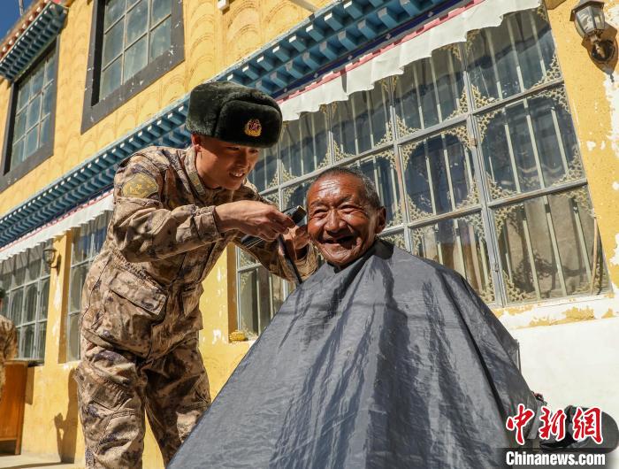 圖為阿里軍分區(qū)某邊防團(tuán)官兵為駐地群眾理發(fā)迎藏歷新年?！〉┰鰝愔?攝