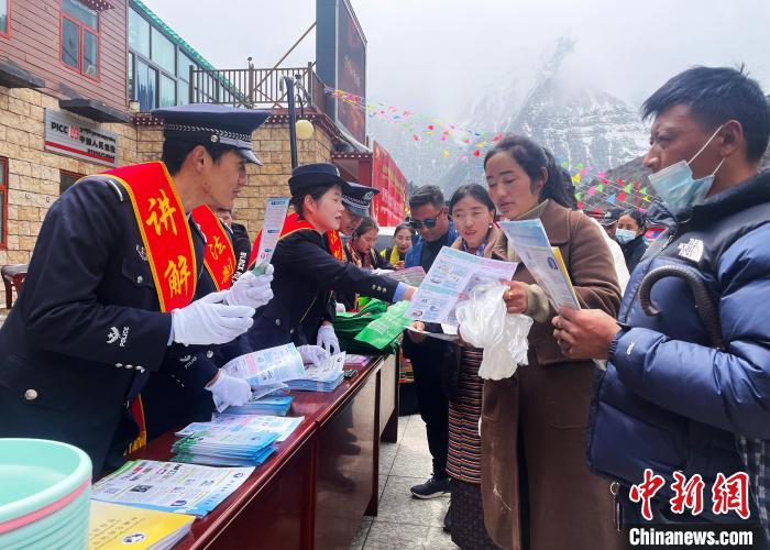 圖為山南玉麥邊境派出所民警為轄區(qū)群眾發(fā)放法律知識(shí)宣傳單?！＄婗?　攝