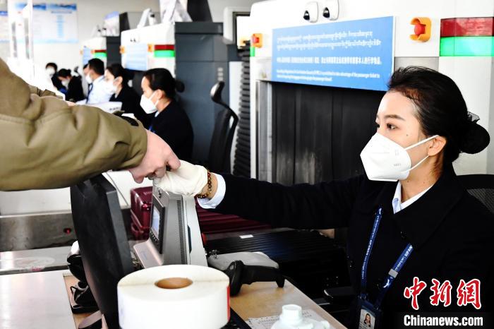 圖為機場工作人員為旅客辦理行李托運?！≈芎?攝