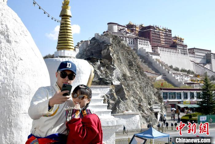 4月17日，游客身著藏式元素服裝在拉薩布達拉宮觀景臺拍照留念?！±盍?攝