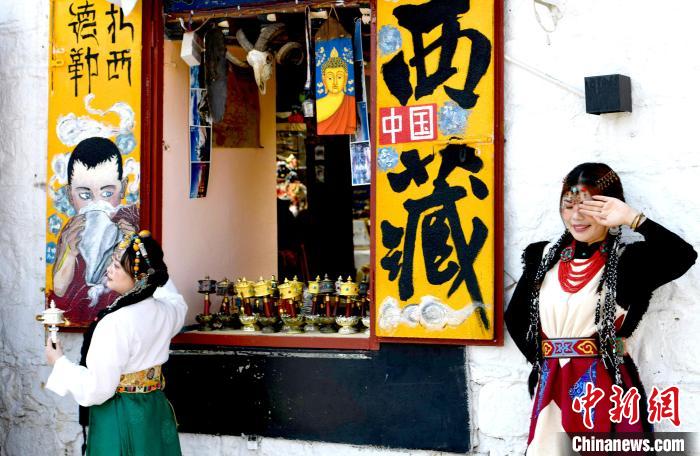 4月17日，游客身著藏式元素服裝在拉薩八廓街拍照留念。　李林 攝
