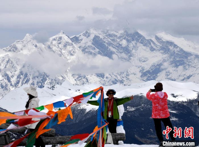 圖為5月14日，西藏林芝色季拉山觀景臺(tái)，游客與南迦巴瓦峰合影。　李林 攝