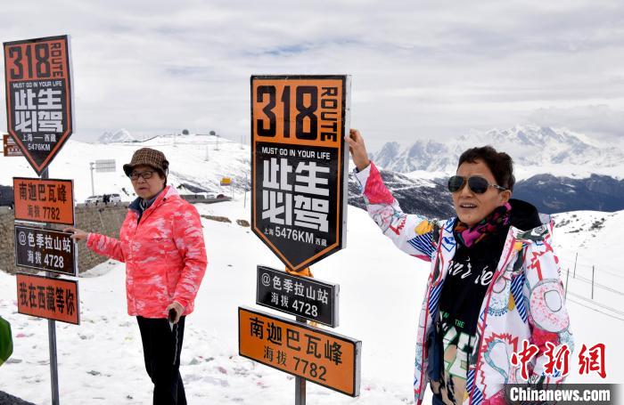 圖為5月14日，西藏林芝色季拉山觀景臺(tái)，游客與南迦巴瓦峰合影?！±盍?攝