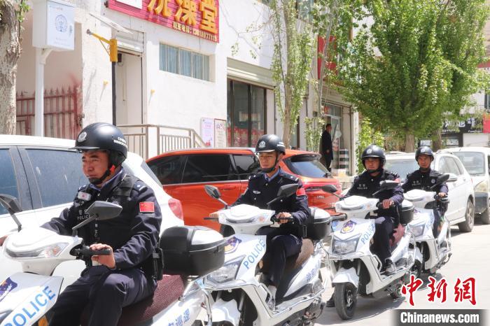 民警騎著電瓶車在轄區(qū)巡邏走訪。　黃創(chuàng)偉 攝