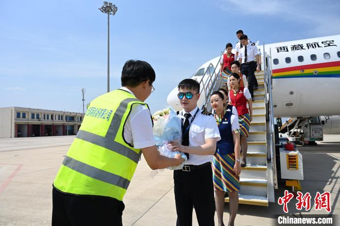 圖為機組順利抵達(dá)后獲贈祝賀?！≮w朗 攝