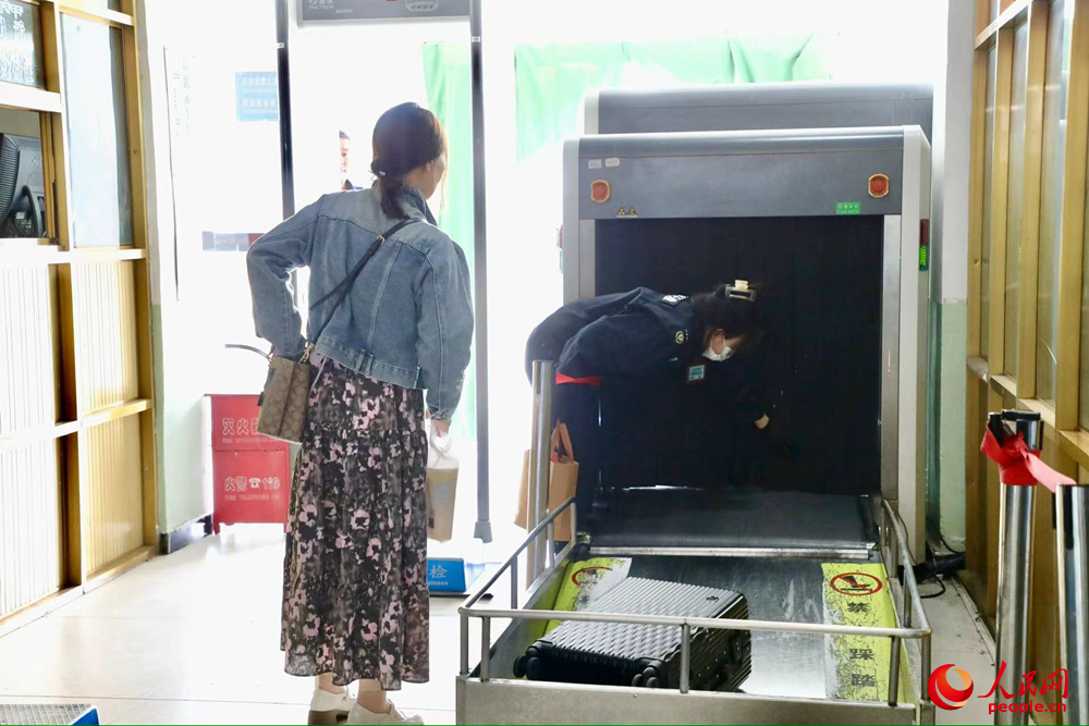 車(chē)站工作人員幫旅客提取行李。人民網(wǎng)記者 次仁羅布攝