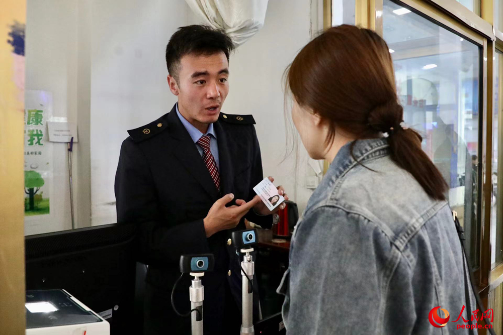 車(chē)站工作人員向旅客解答疑問(wèn)。人民網(wǎng)記者 次仁羅布攝