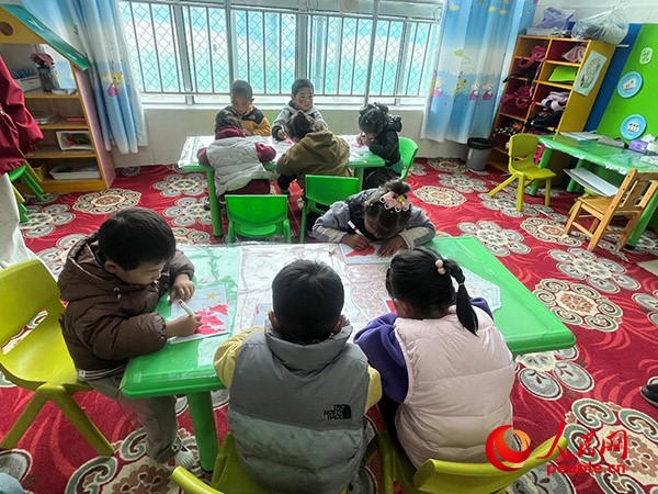 拉多村一所現(xiàn)代化幼兒園小班孩子們正在繪畫。張敏穎 攝