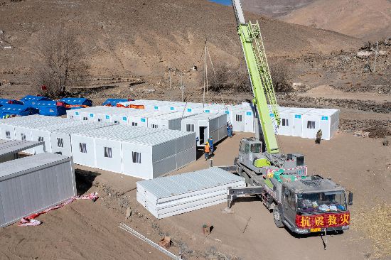 2025年1月9日，在定日縣長所鄉(xiāng)古榮村安置點(diǎn)，救援人員和施工人員合力抓緊搭建移動(dòng)板房，確保受災(zāi)群眾溫暖過冬。人民網(wǎng)記者 翁奇羽攝