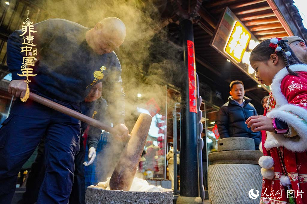 2025年1月29日，浙江省寧波市江北區(qū)慈城古縣城，市民和游客觀看搗年糕。人民網(wǎng) 章勇濤攝