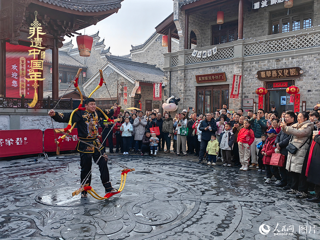 2025年1月29日，湖北襄陽市管家巷，老北京天橋大刀張舉大刀拉硬弓第五代傳承人現(xiàn)場表演，一次拉開6張弓，引來游客喝彩。人民網(wǎng)記者 郭婷婷攝