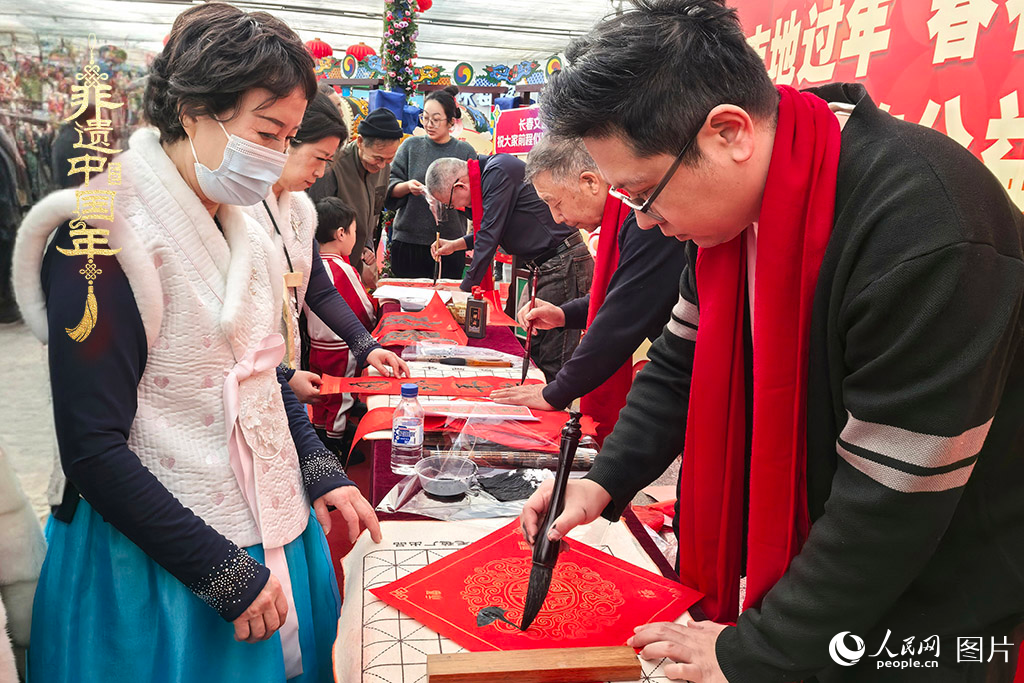 新春佳節(jié)之際，長春農(nóng)博園冬季展會火熱進行，展廳內，書法家現(xiàn)場書寫“?！弊?，市民游客紛紛上前迎春接“?！?。人民網(wǎng)記者 王海躍攝