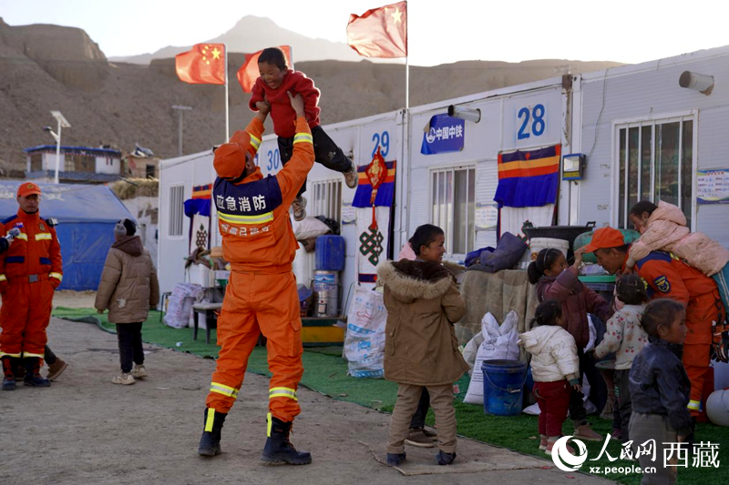 熱木青村安置點(diǎn)，消防員們同孩子們嬉戲玩耍。人民網(wǎng)記者 次仁羅布攝